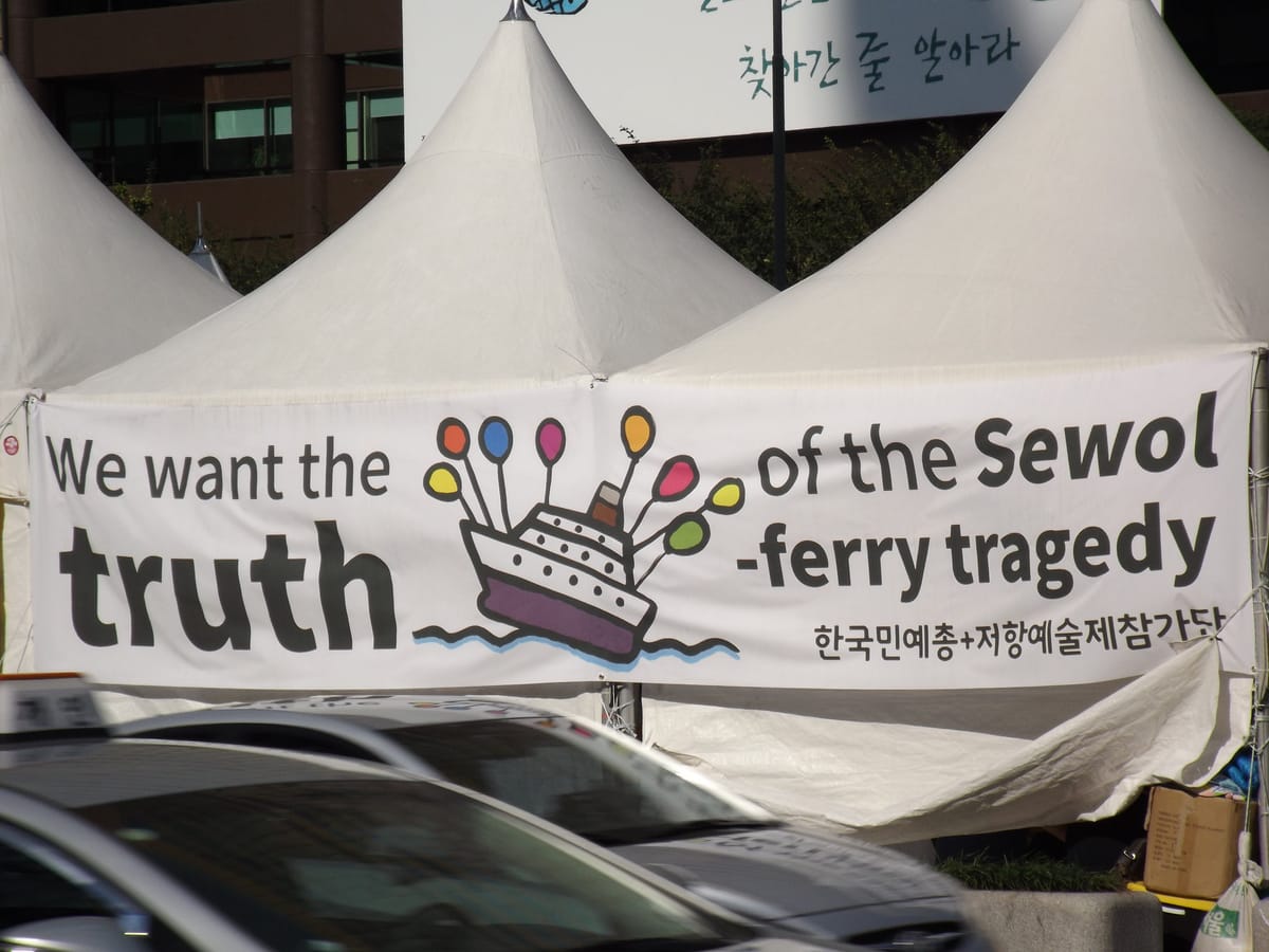 Protest banner in English and Korean: "We want the truth of the Sewol ferry tragedy"