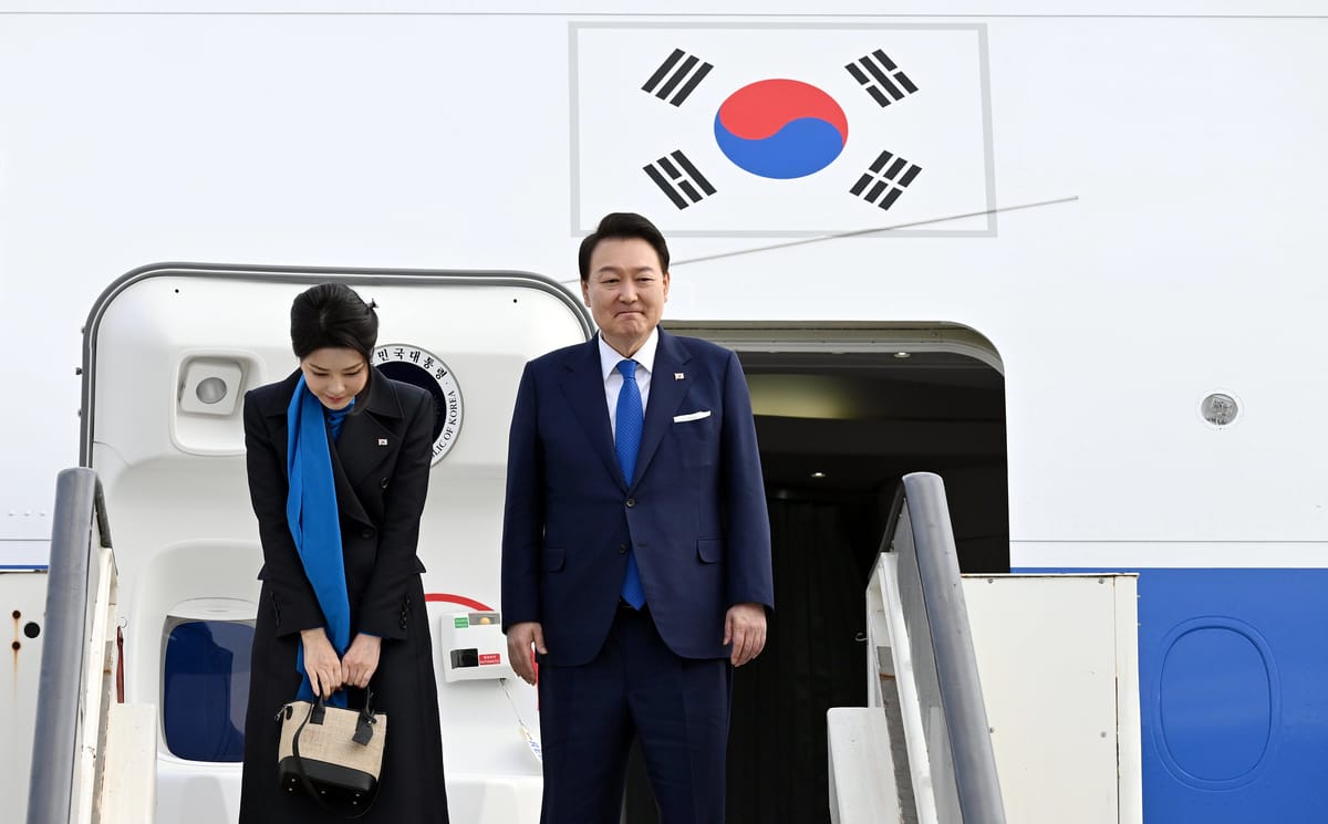 First Lady Kim Keon Hee grasping handbag with President Yoon Suk Yeol in front of presidential plane