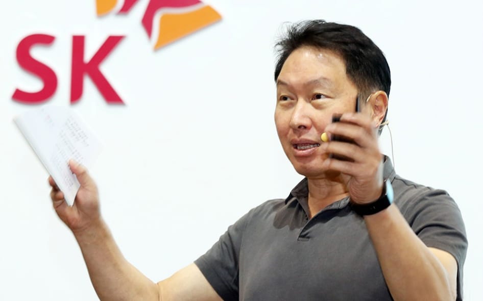 SK Group Chairman Chey Tae-won in front of SK Group logo