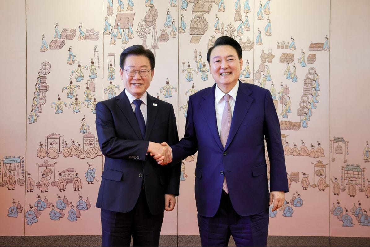 President Yoon Suk-yeol and Democratic Party leader Lee Jae-myung shake hands at summit