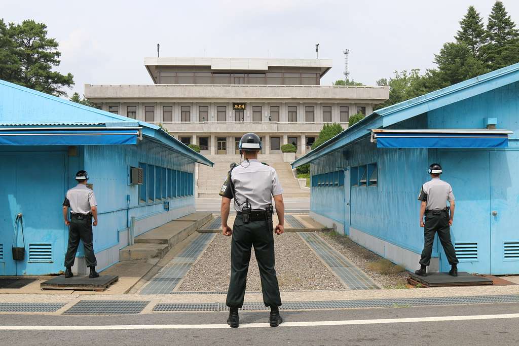 A South Korean soldier stands guard at Panmunjom between two blue buildings