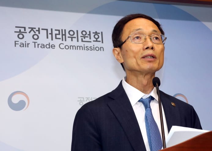 A Korean FTC administrator stands in front of the KFTC logo at a microphone