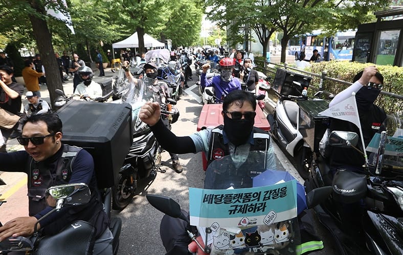 Many Delivery app workers filling the street riding mopeds during a protest