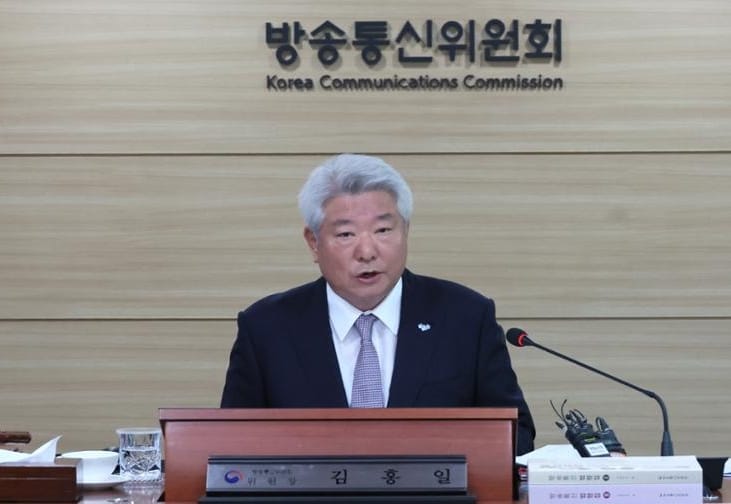 KCC Chairman Kim Hong-il seated at a lectern in from of the KCC commission nameplate