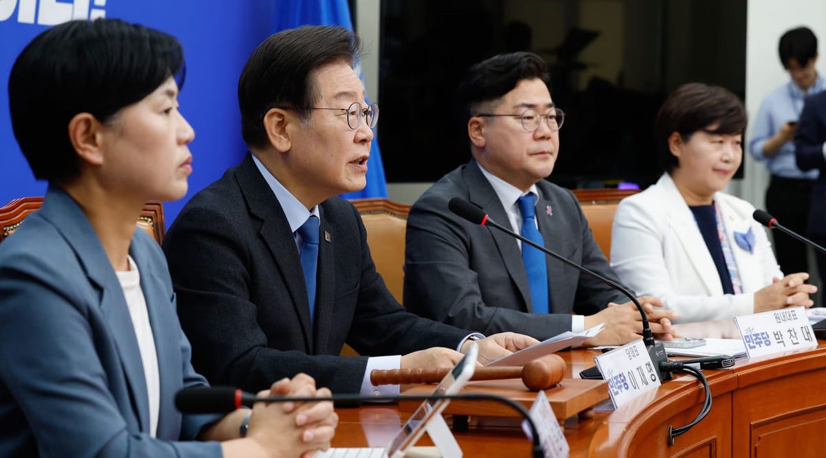 Lee Jae-myung seated at a circular conference table with DPK supreme council members