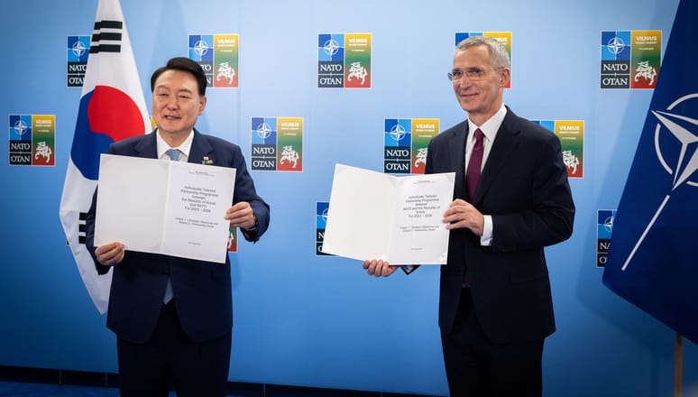 RoK President Yoon Suk Yeol and NATO Secretary General Jens Stoltenberg display signed documents in July 2023