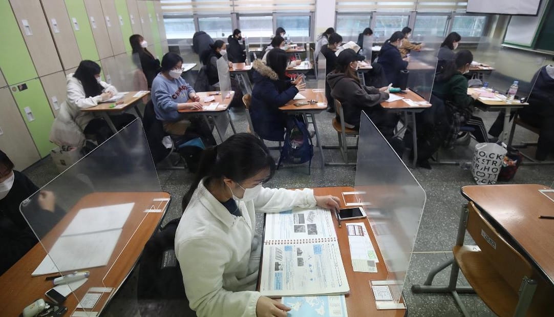 South Korean students seated at desks taking exam